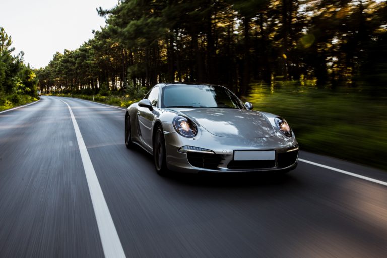 Mini coupe racing car high speed drive on the road with front lights on